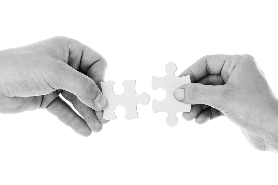 Image of two hands holding a jigsaw piece
